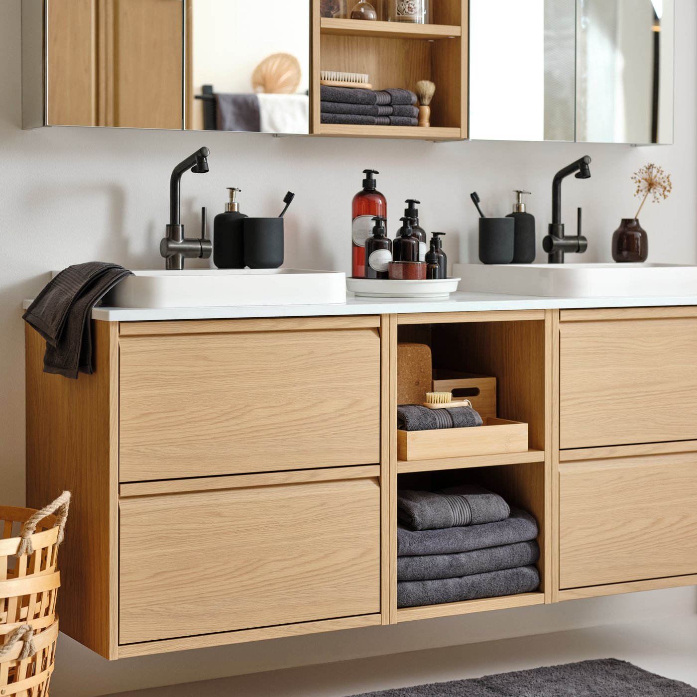 Ett ÄNGSJÖN tvättställ i ekmönstrad design med lådor i badrummet