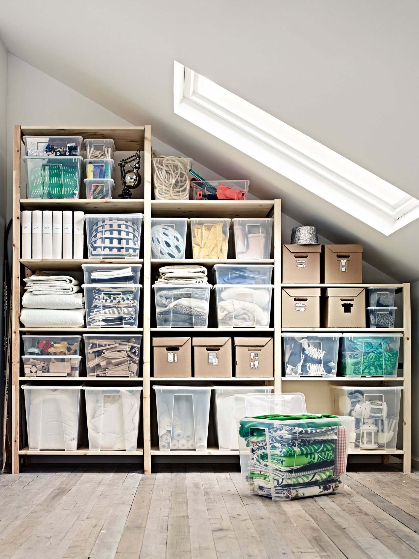 En stor IVAR med en blandning av stängda skåp med dörrar och öppna hyllor med en rund vit lampa och böcker.