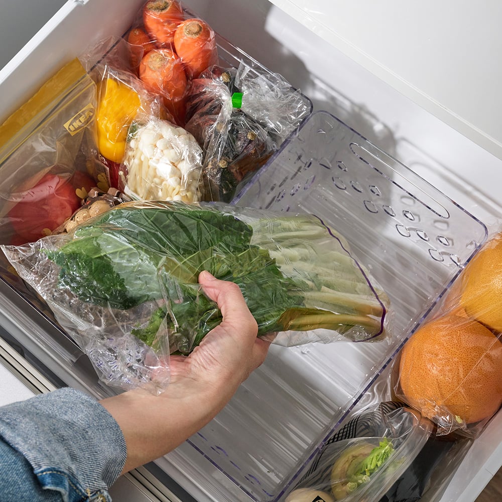 A transparent KLIPPKAKTUS storage basket for fridge