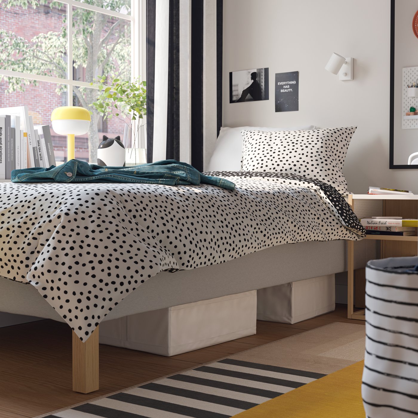 SKUBB förvaringslådor ligger under en ljusbeige RENFJÄLLET resårbotten med pocketresårer, bäddad med BJÖRKGRÅMAL sängkläder i ett sovrum.
