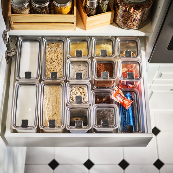 A kitchen drawer organised with KORALLVIPPA dry food jars with lid, storing sugar, nuts, oats, spices and other food.