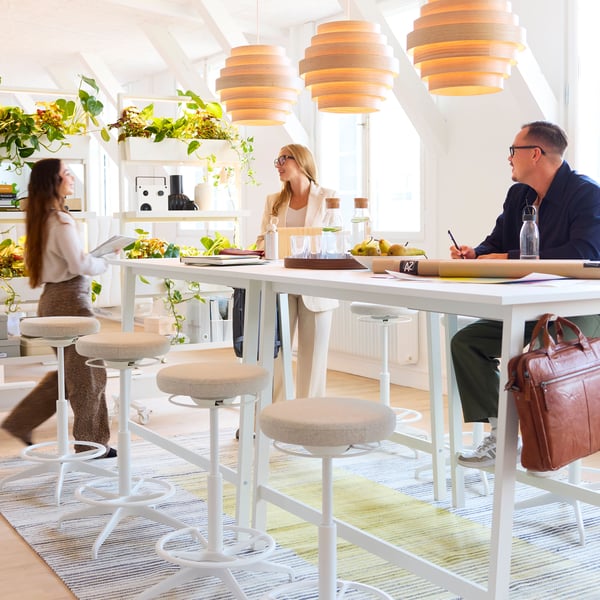 In a bright office, employees work on MITTZON high desks.
