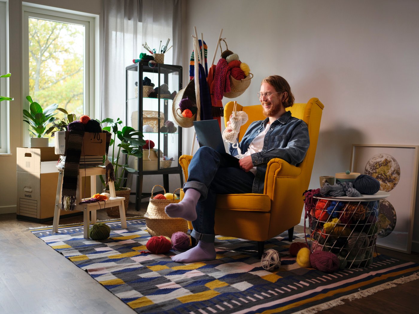 Man sitting on arm chair with laptop on lap
