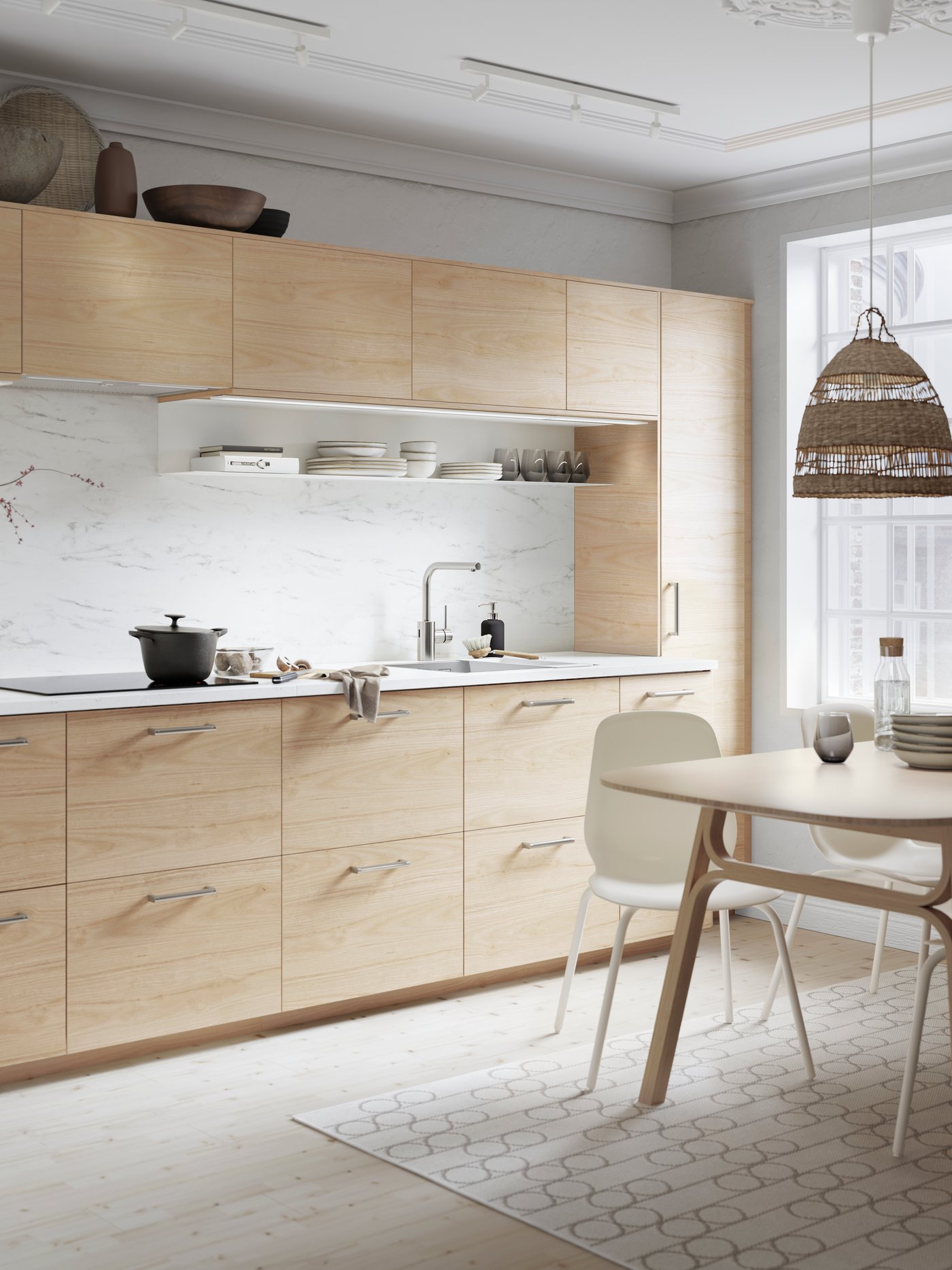 Eine ASKERSUND Küche in heller Eschenachbildung, einer EKBACKEN Arbeitsplatte in Marmoreffekt und Kochgeschirr auf dem Kochfeld.