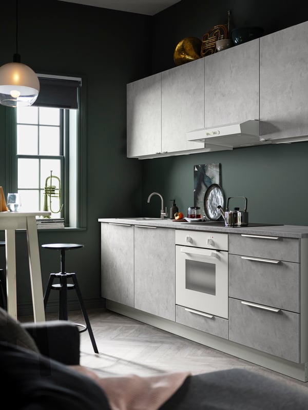 A kitchen with ENHET kitchen cabinets, a LAGAN oven in white and a JAKOBSBYN pendant lamp hanging from above.
