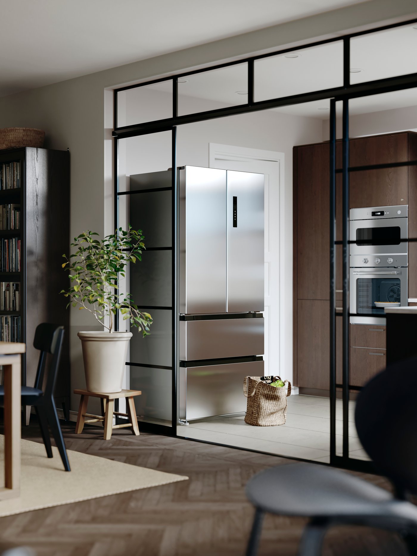 Billede taget fra en stue, hvor man kan se et moderne køkken længere væk.