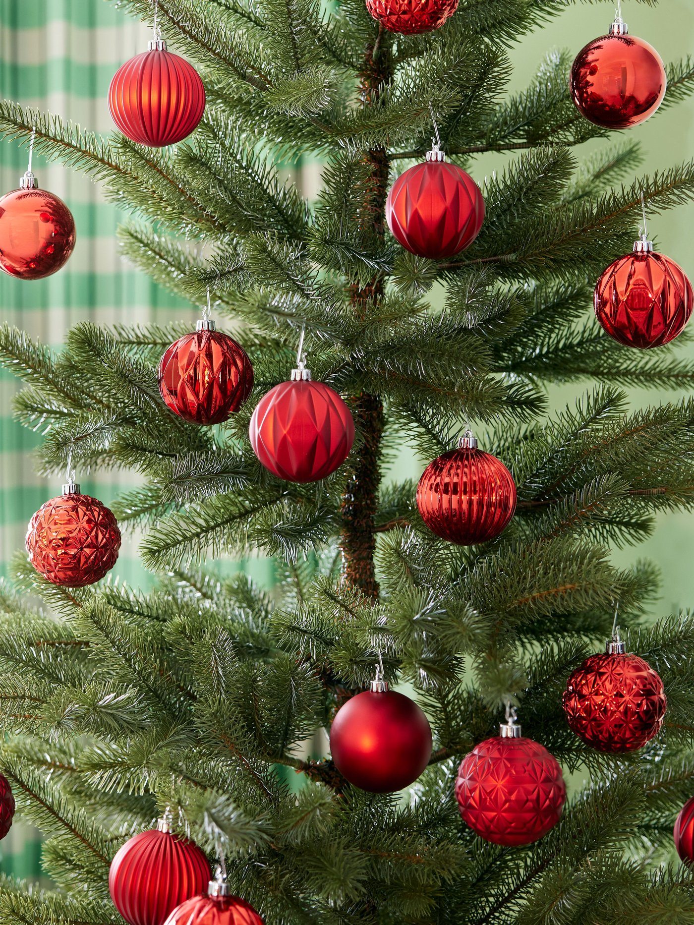 Árbol de navidad con decoración navideña roja.