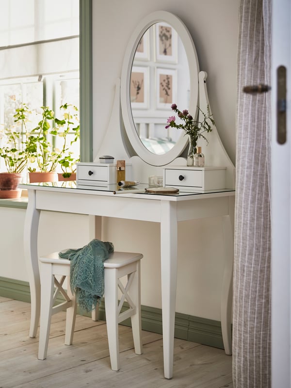HEMNES Schminkspiegel mit dem INGOLF Hocker in einem Raum.