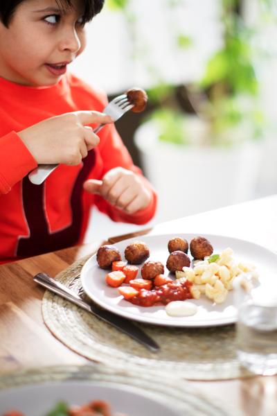 Ett barn äter köttbullar