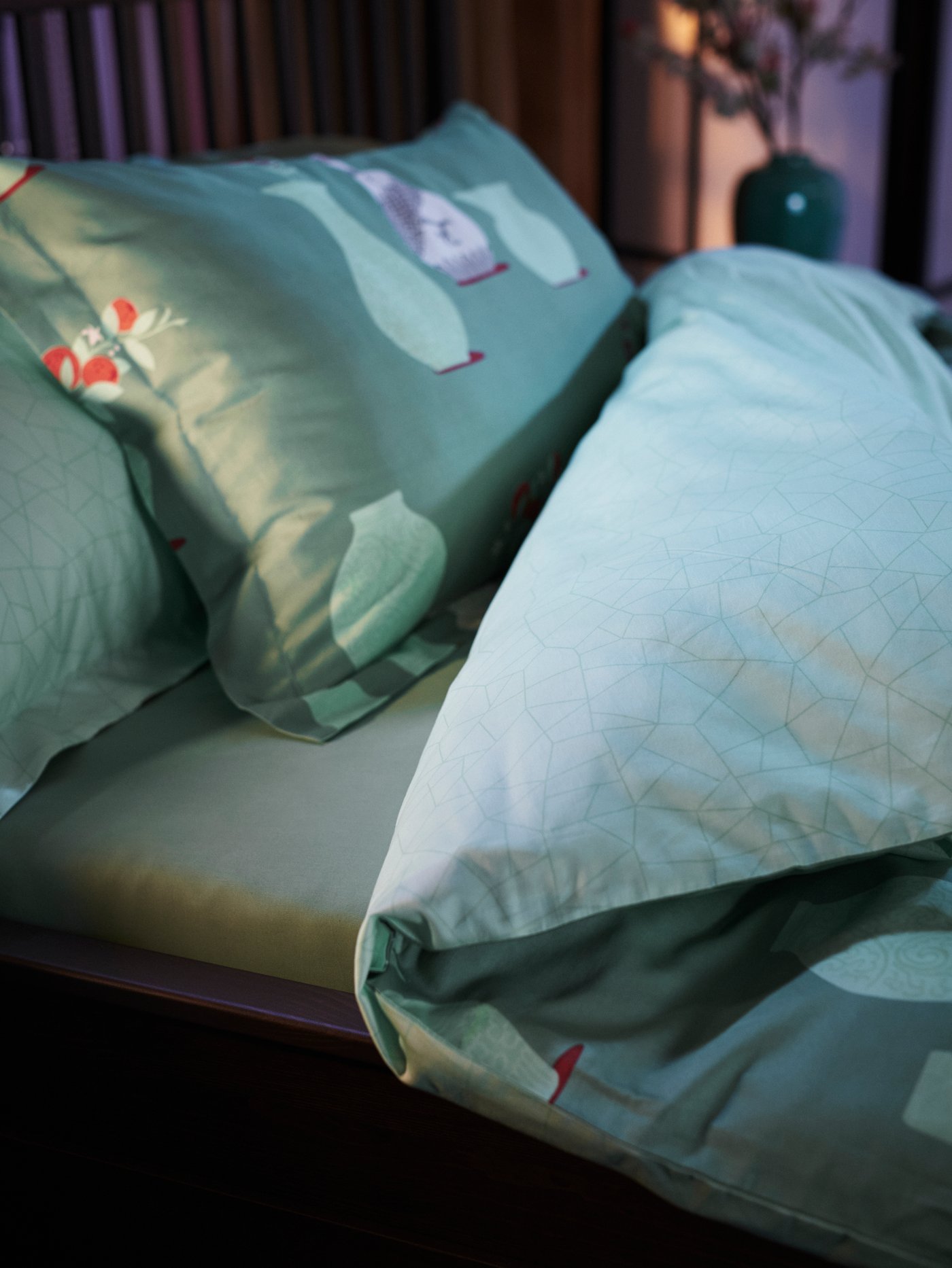 Gambar dekat katil dengan sarung bantal FÖSSTA dan sarung duvet FÖSSTA. Duvet itu telah dilipat dengan kemas.