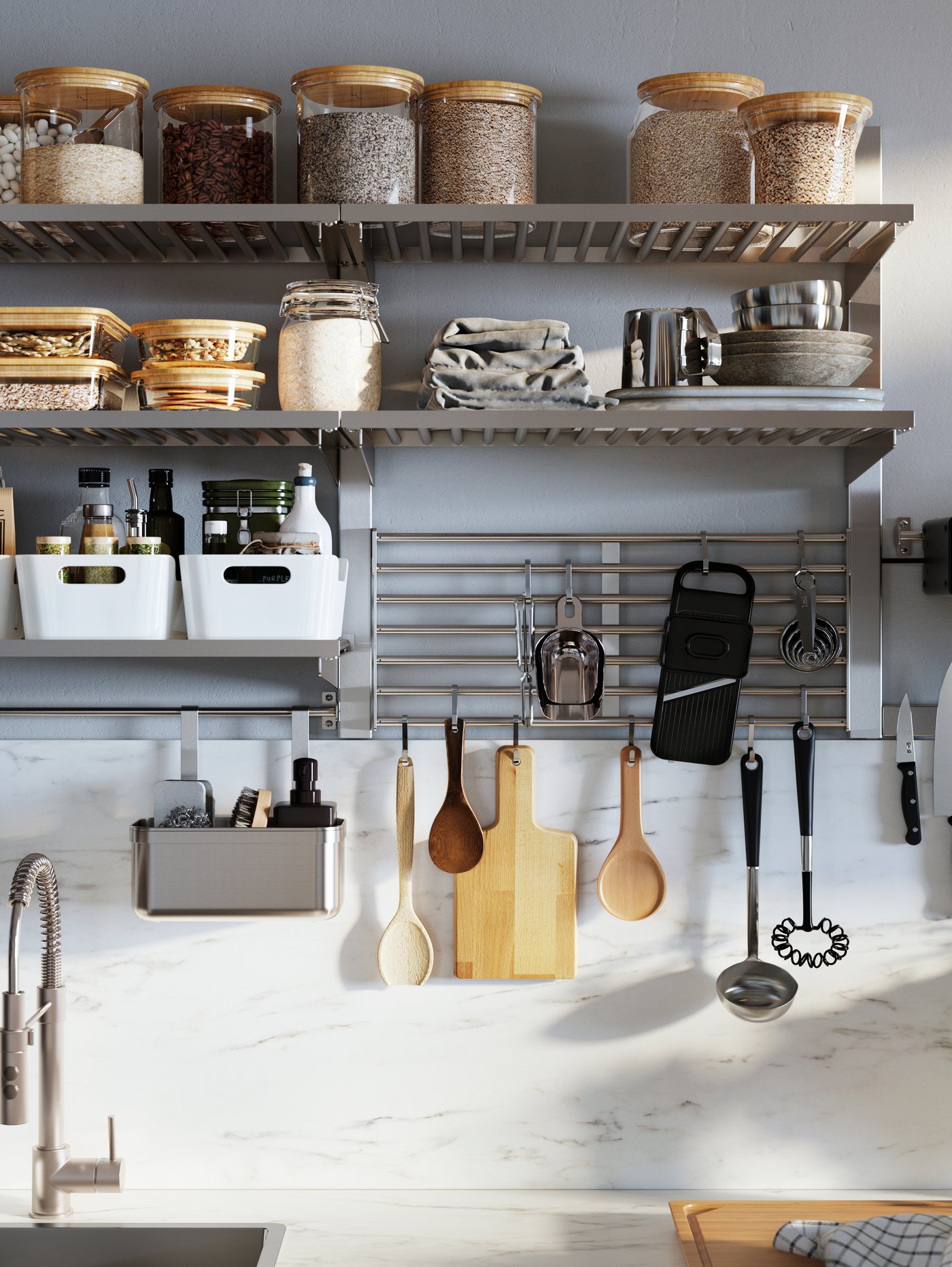 Pared de cocina con rieles de montaje para estantes, en los que hay tarros con tapa, recipientes para alimentos y cajas rectangulares.