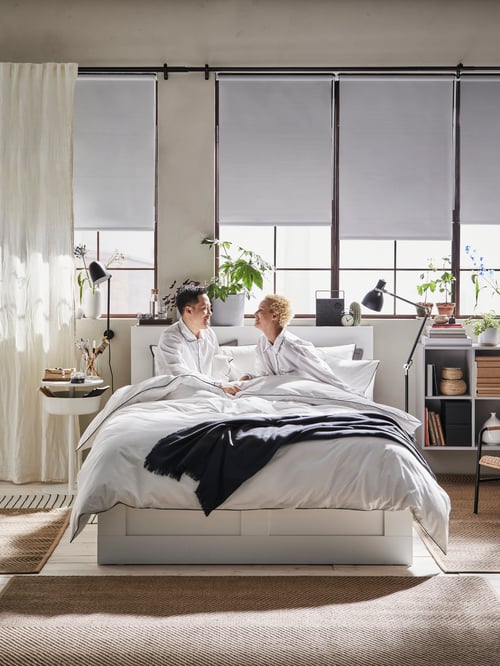 Bedroom with bedframe, drawers, headboard, throw, quilt cover, pillowcases, wall and floor lamps, curtains, cabinet, speaker.
