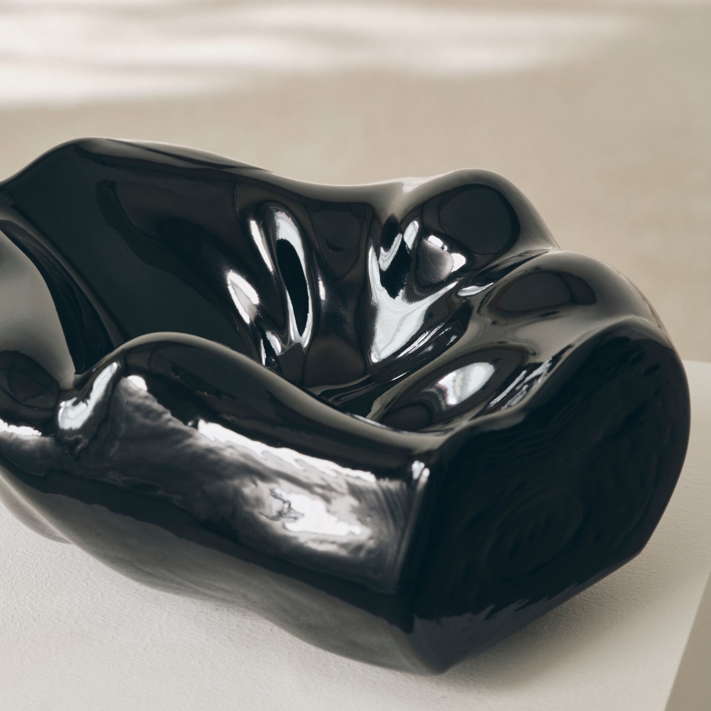 Close up of a shiny black bowl sculpture from the IKEA art collection KONSTRUNDA.