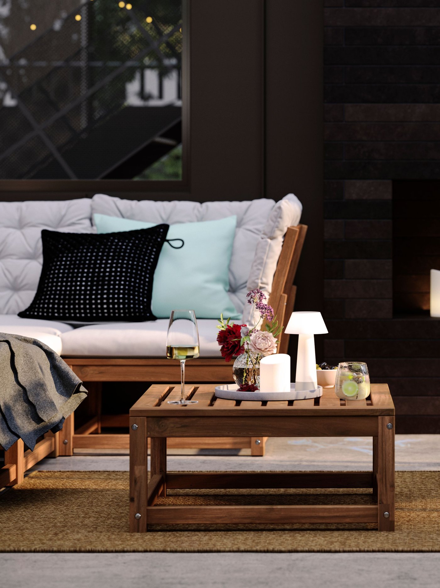 A patio with light brown stained outdoor NÄMMARÖ lounge seating and a seat section for a modular sofa doubling as a table.