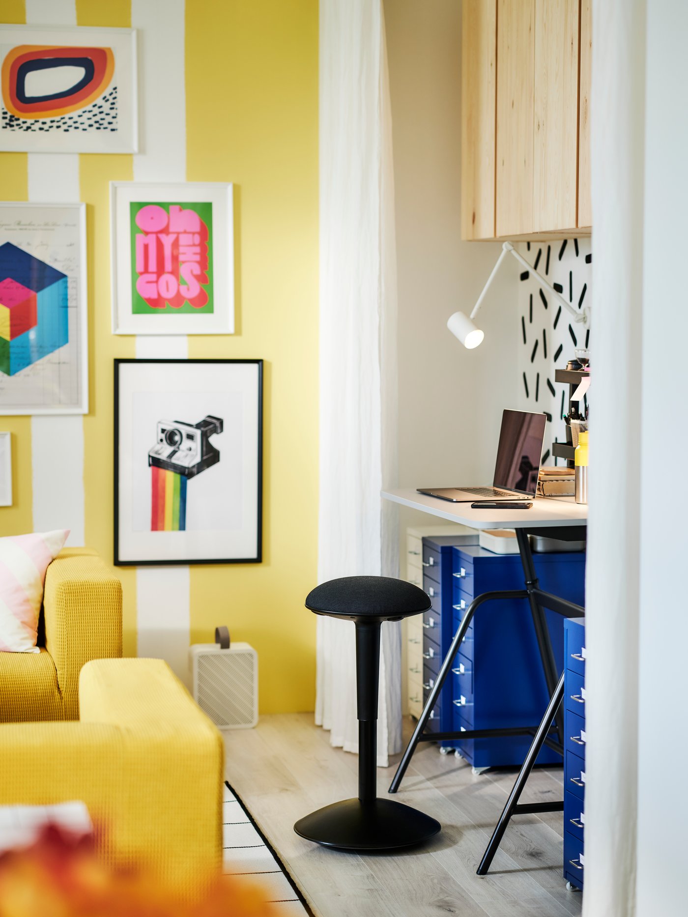A colourful room with a workspace flanked by blue HELMER drawer units on castors and a NILSERIK standing support.