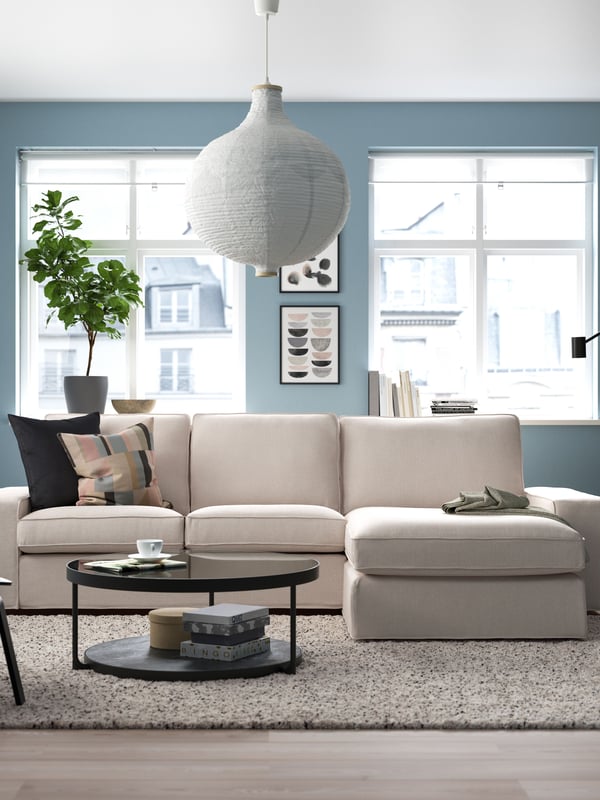 A Tibbleby beige/grey KIVIK 3-seater sofa with chaise longue in a living room with blue walls