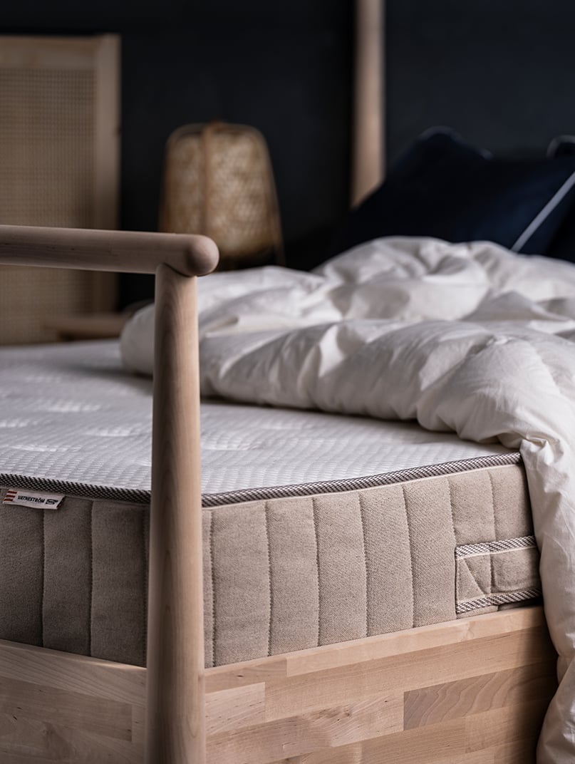 Un matelas à ressorts ensachés VATNESTRÖM ferme/naturel dans la chambre à coucher