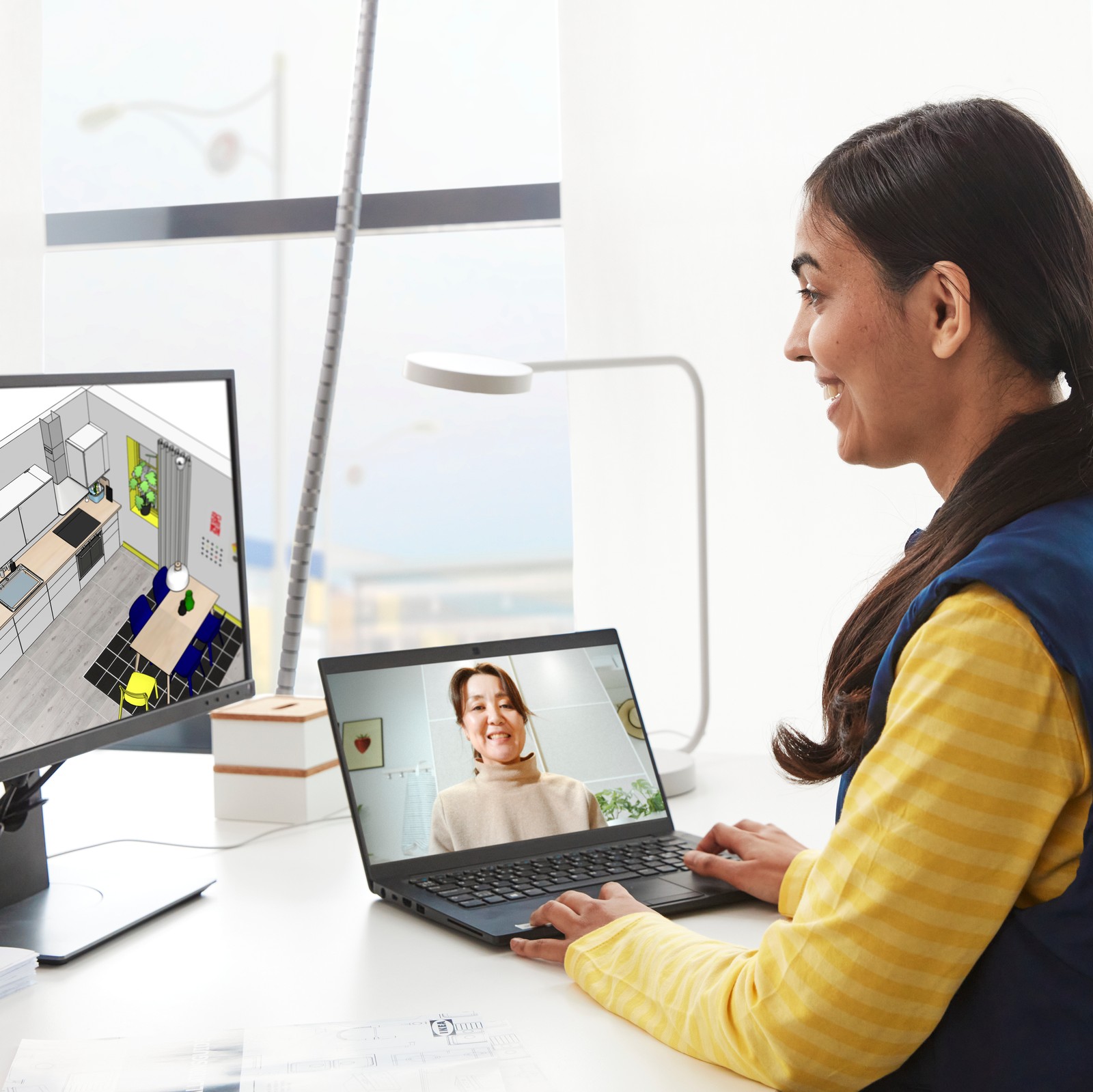 O angajată IKEA și o clientă discută un proiect de planificare a unei bucătării în cadrul unui apel video.