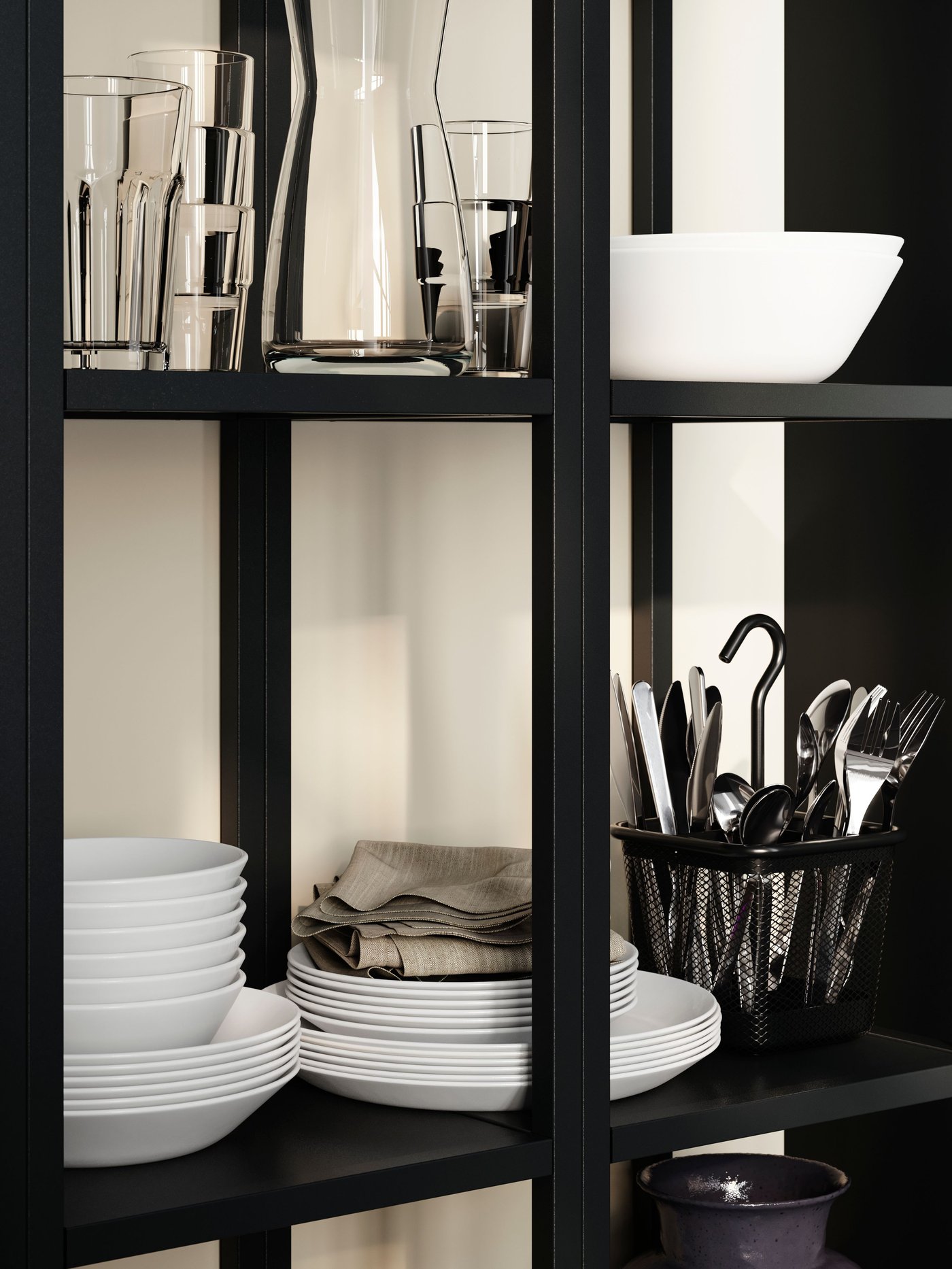 OFTAST bowls stacked on a black shelf alongside glasses and cutlery in a basket, with napkins neatly folded.