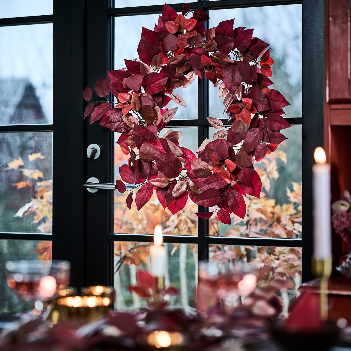 An in/outdoor red SMYCKA artificial wreath in the dining room
