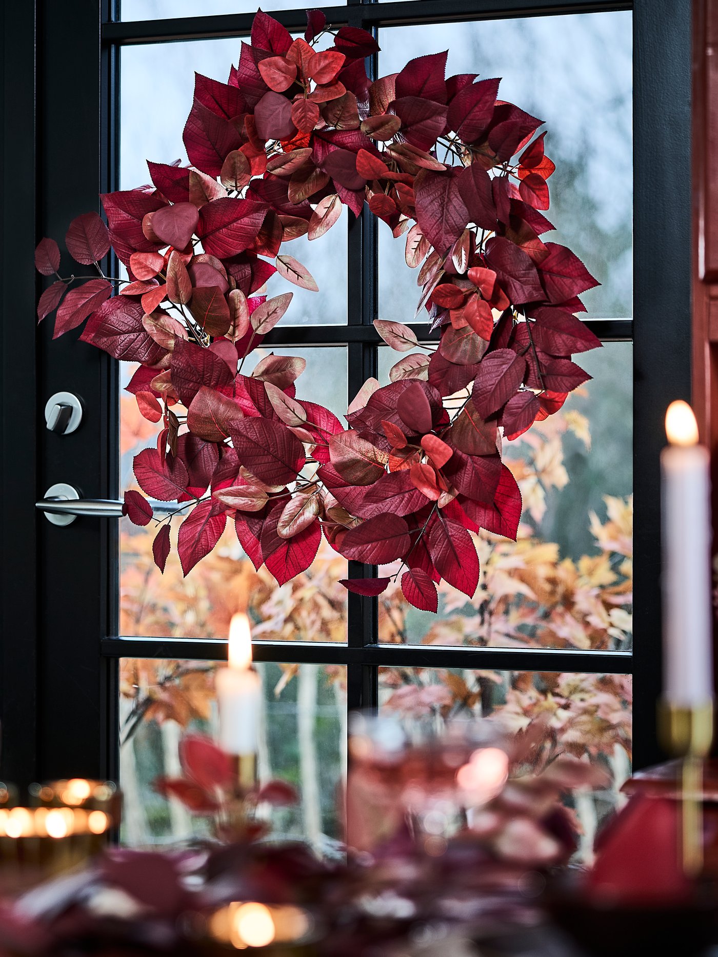 An in/outdoor red SMYCKA artificial wreath in the dining room