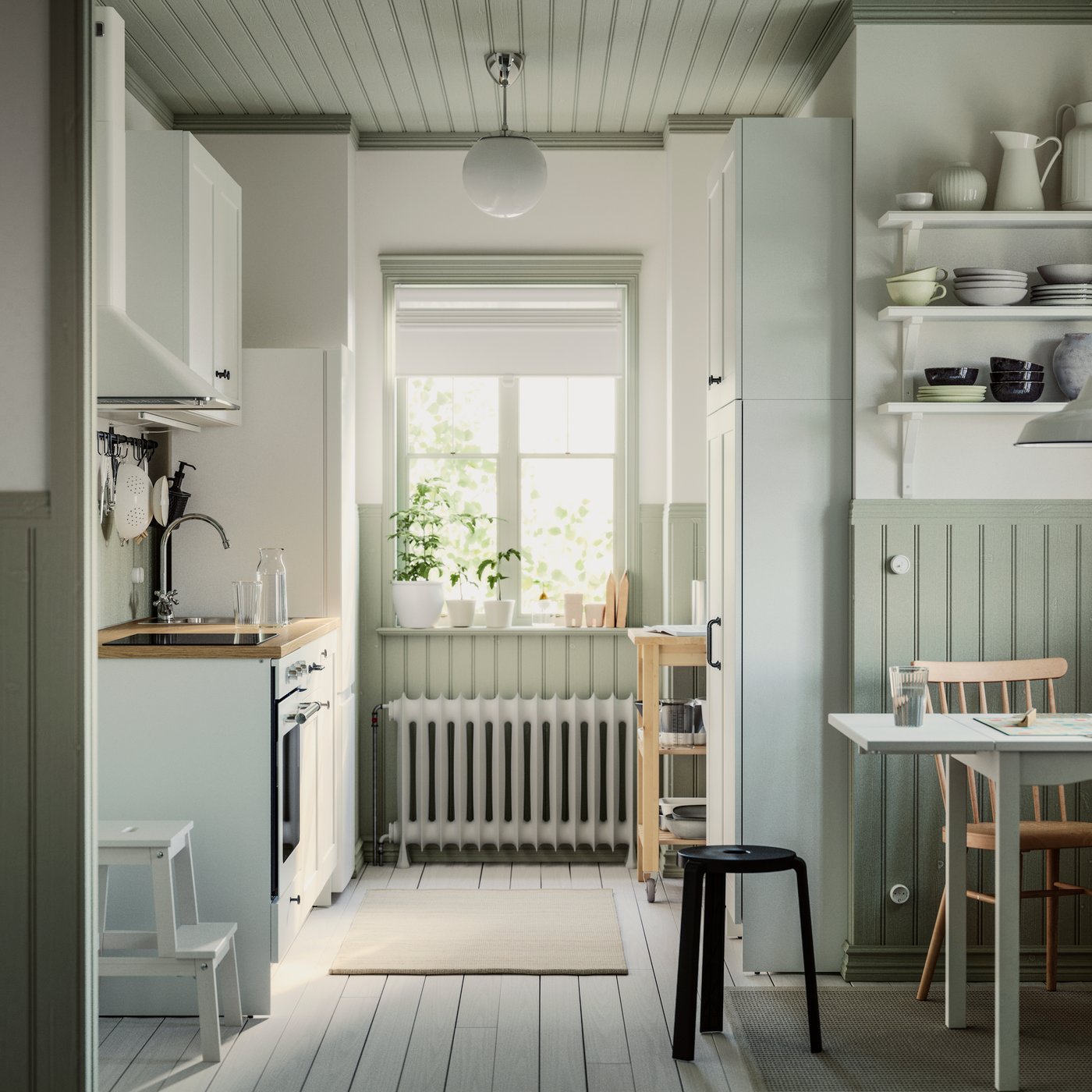 A small parallel kitchen with a window has white KNOXHULT cabinets, a dining table, a rug on the floor and a step stool.