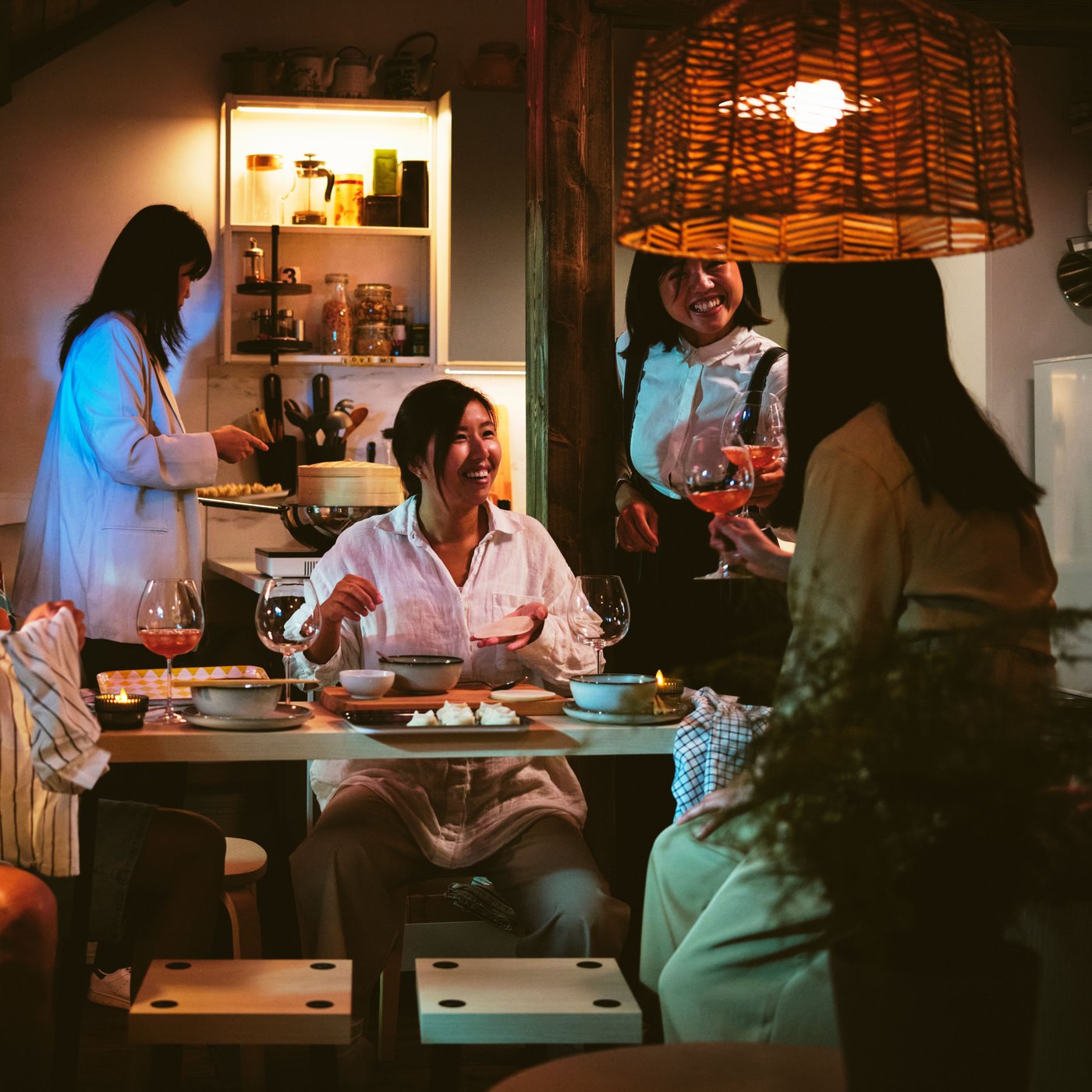 Fire personer er samlet om etFRIDNÄS Indskudsborde med taburetter