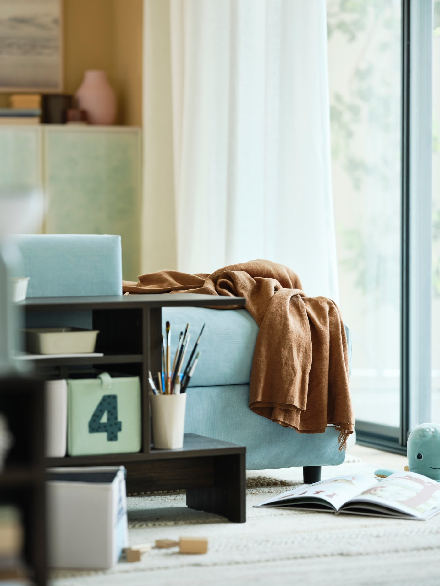 En närbild på en ljusblå VIMLE soffa och ett HOLMERUD sidobord.