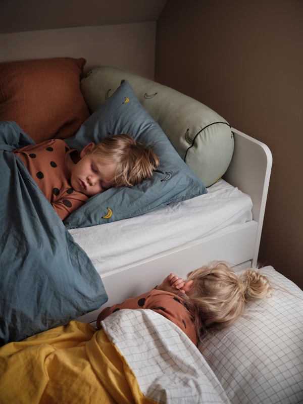 Deux enfants dormant confortablement dans leur lit
