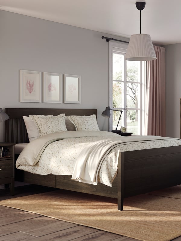 A dark brown stained IDANÄS bed frame with storage