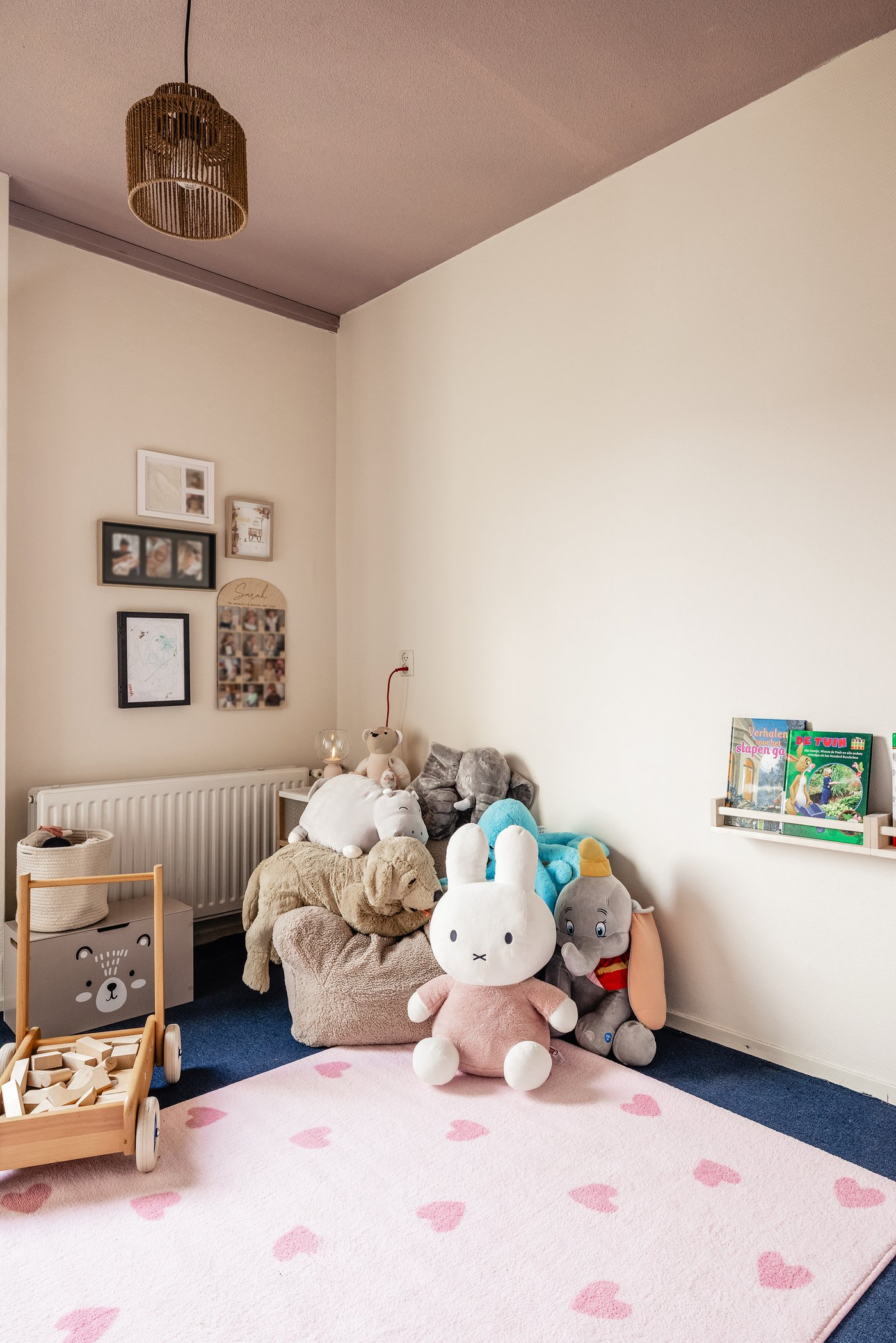 In de hoek van een kinderkamer staat een stoel met daaromheen meerdere knuffels. Op de grond ligt een roze BARNDRÖM vloerkleed.