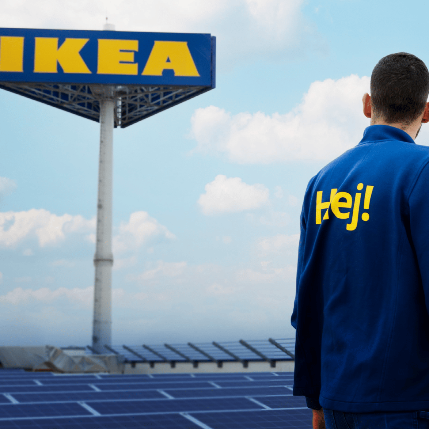 A co-worker stands in front of an IKEA sign, surrounded by solar panels under a clear sky