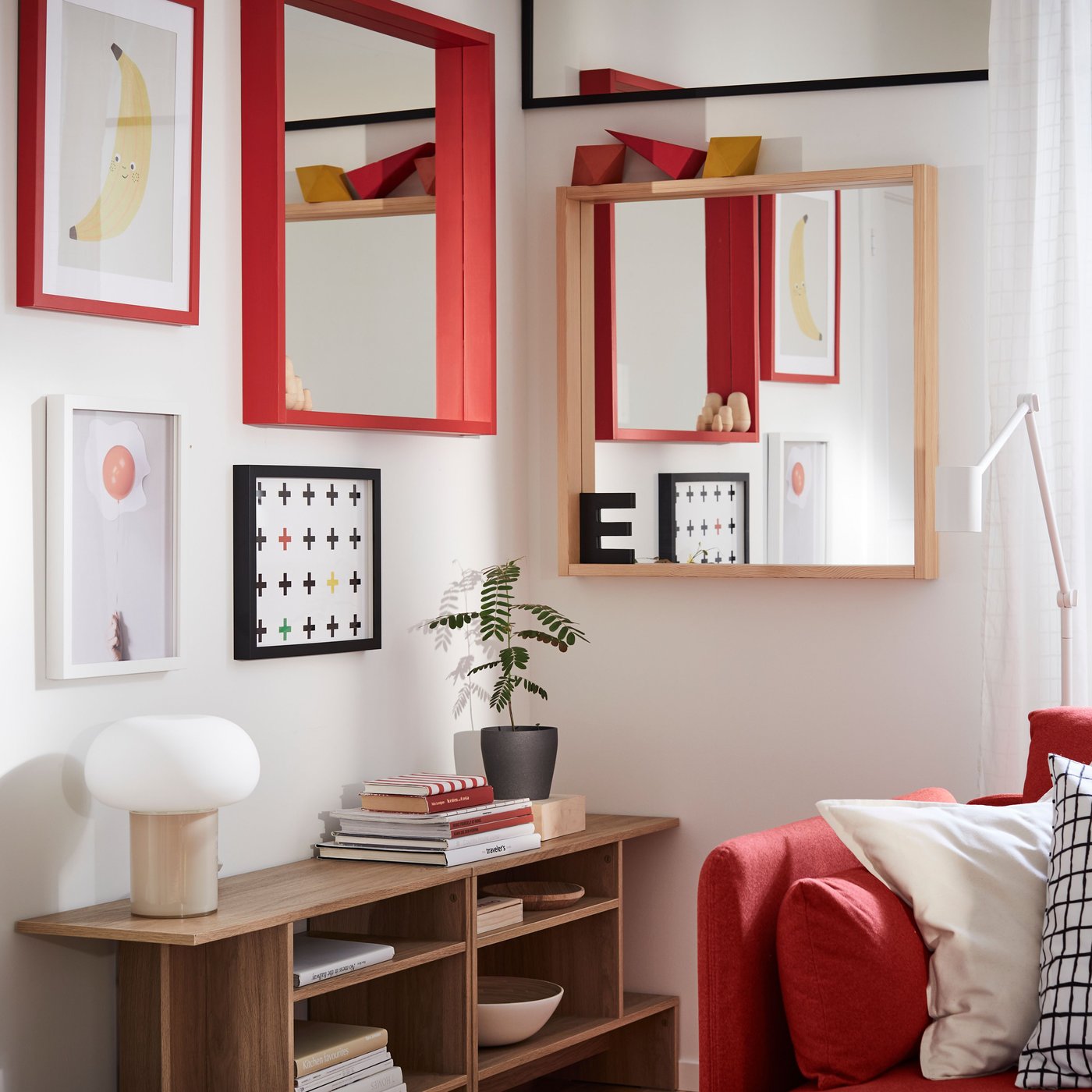 Ein TURBOKASTANJ Spiegel, ein roter TURBOKASTANJ Spiegel und einige Kunstwerke hängen an den Wänden in einer Ecke des Wohnzimmers.