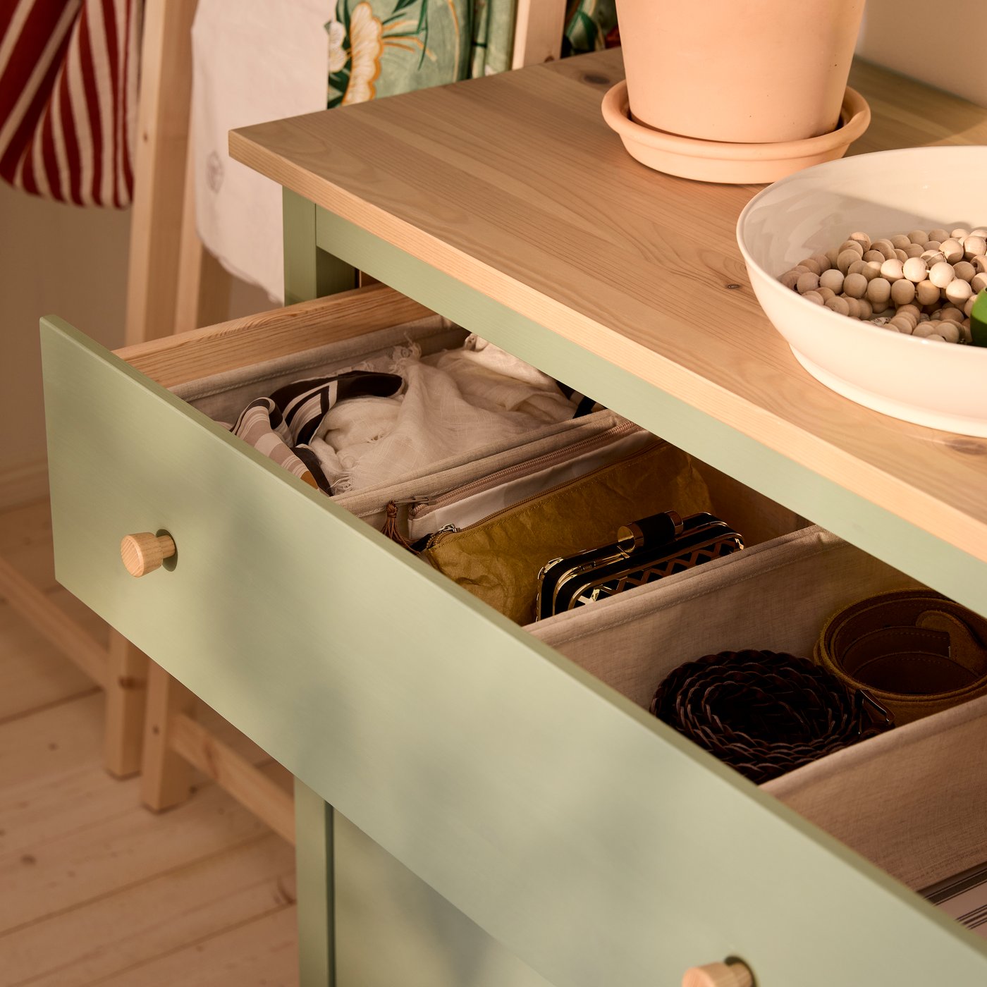 Zbliżenie na komodę HEMNES z wysuniętą górną szufladą, aby pokazać porządek wewnątrz dzięki pudełkom PURRPINGLA.