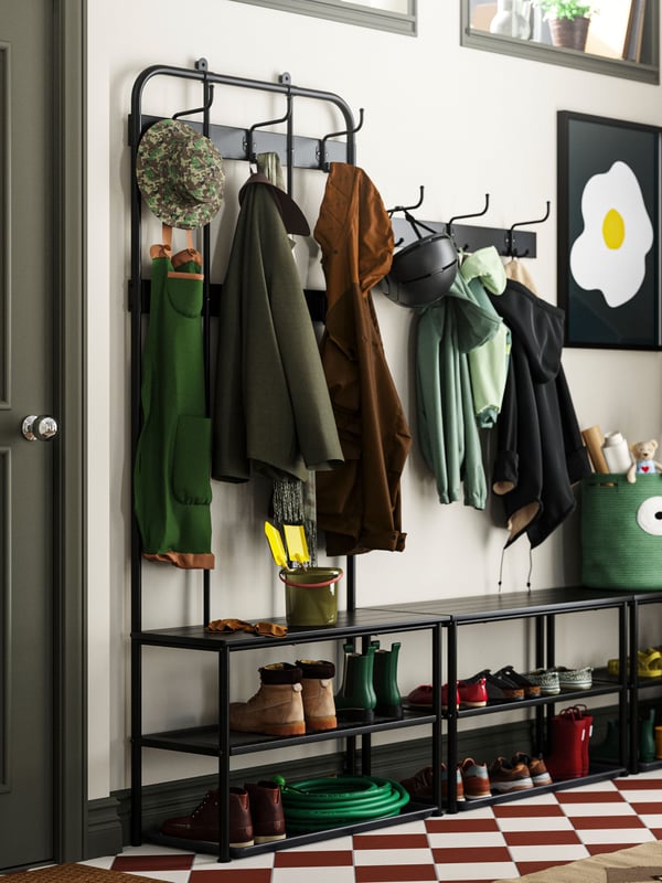 A black PINNIG rack with 3 hooks in the hallway