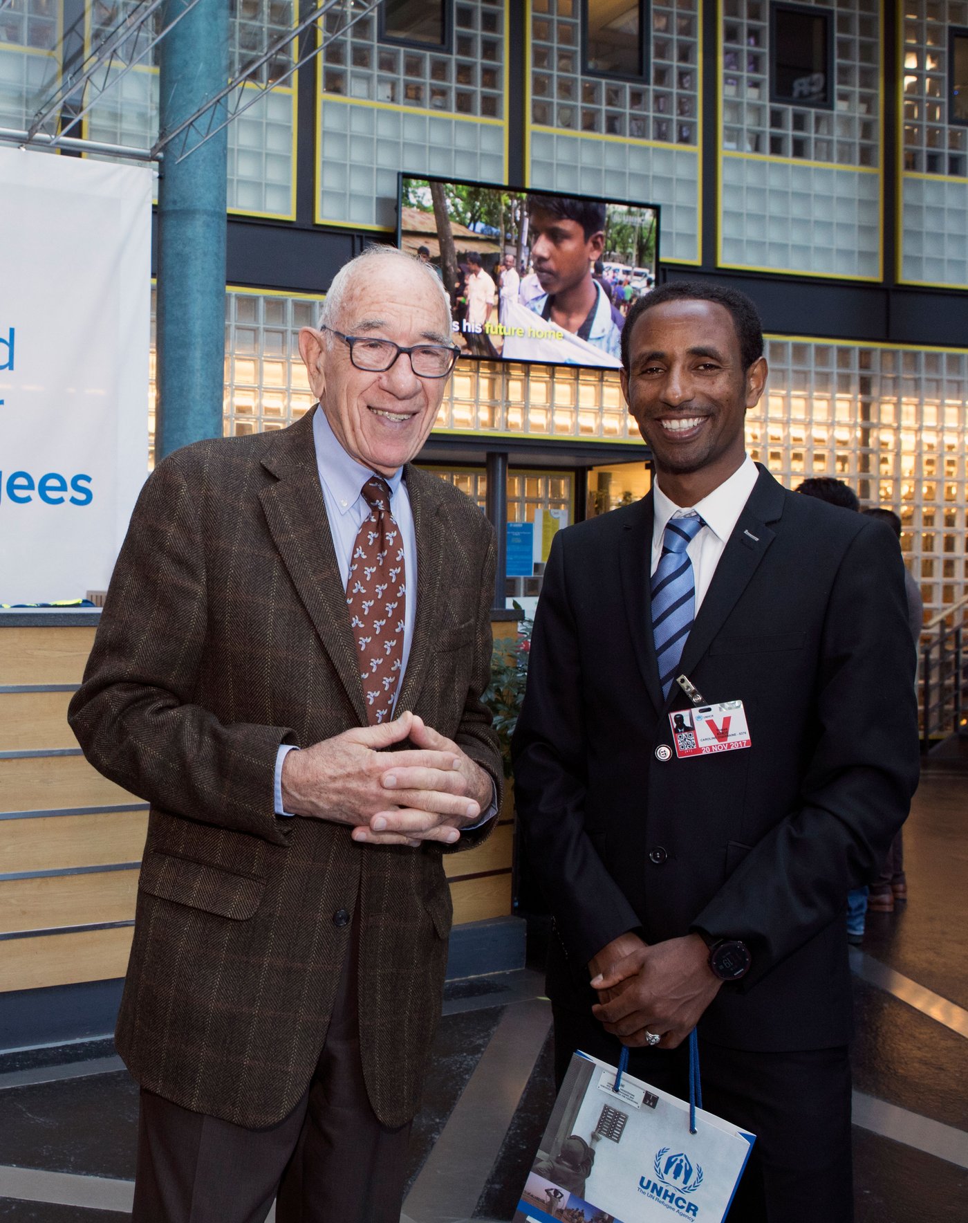 Claude smiling next to a person at a UNCHR event.