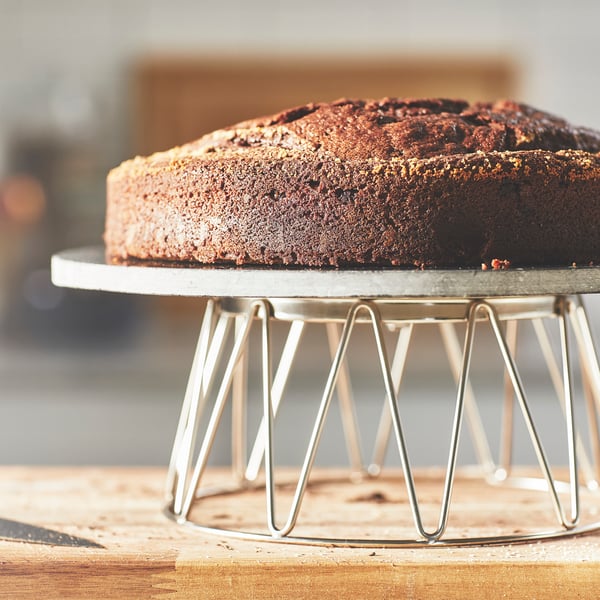 Un présentoir à gâteau BAKGLAD moderne avec un gâteau au chocolat sur le dessus.