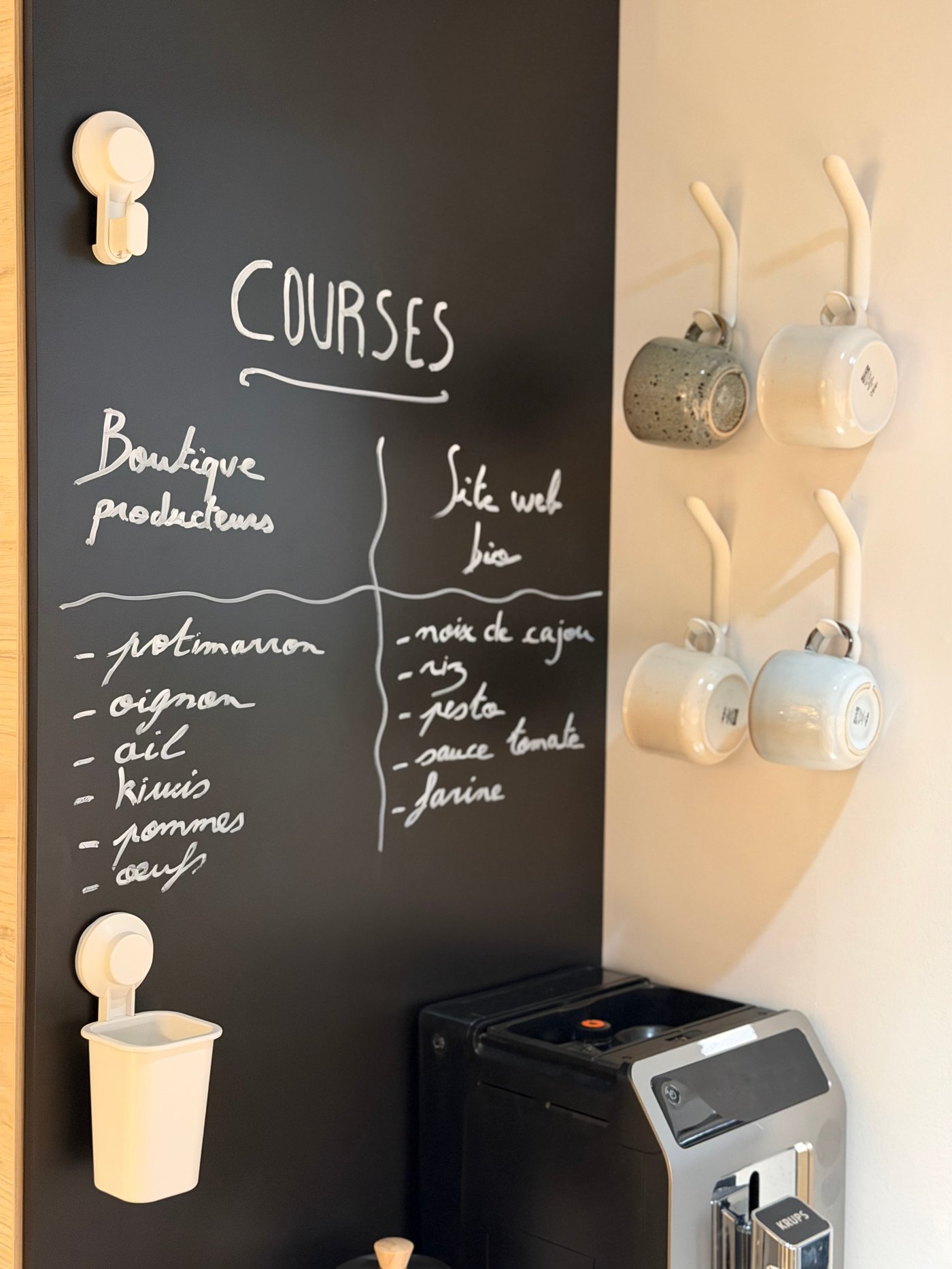 Un tableau noir avec une liste de course écrite et une machine à café.