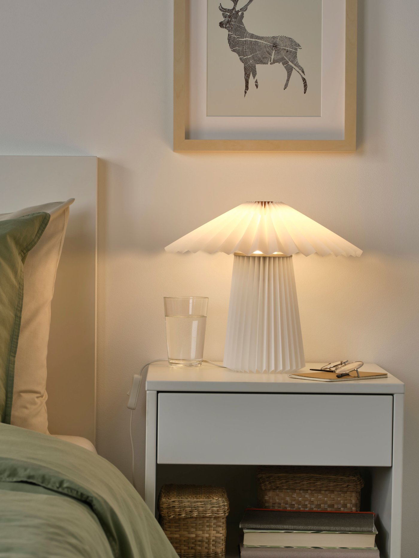 A pleated white KUDDLAVA table lamp