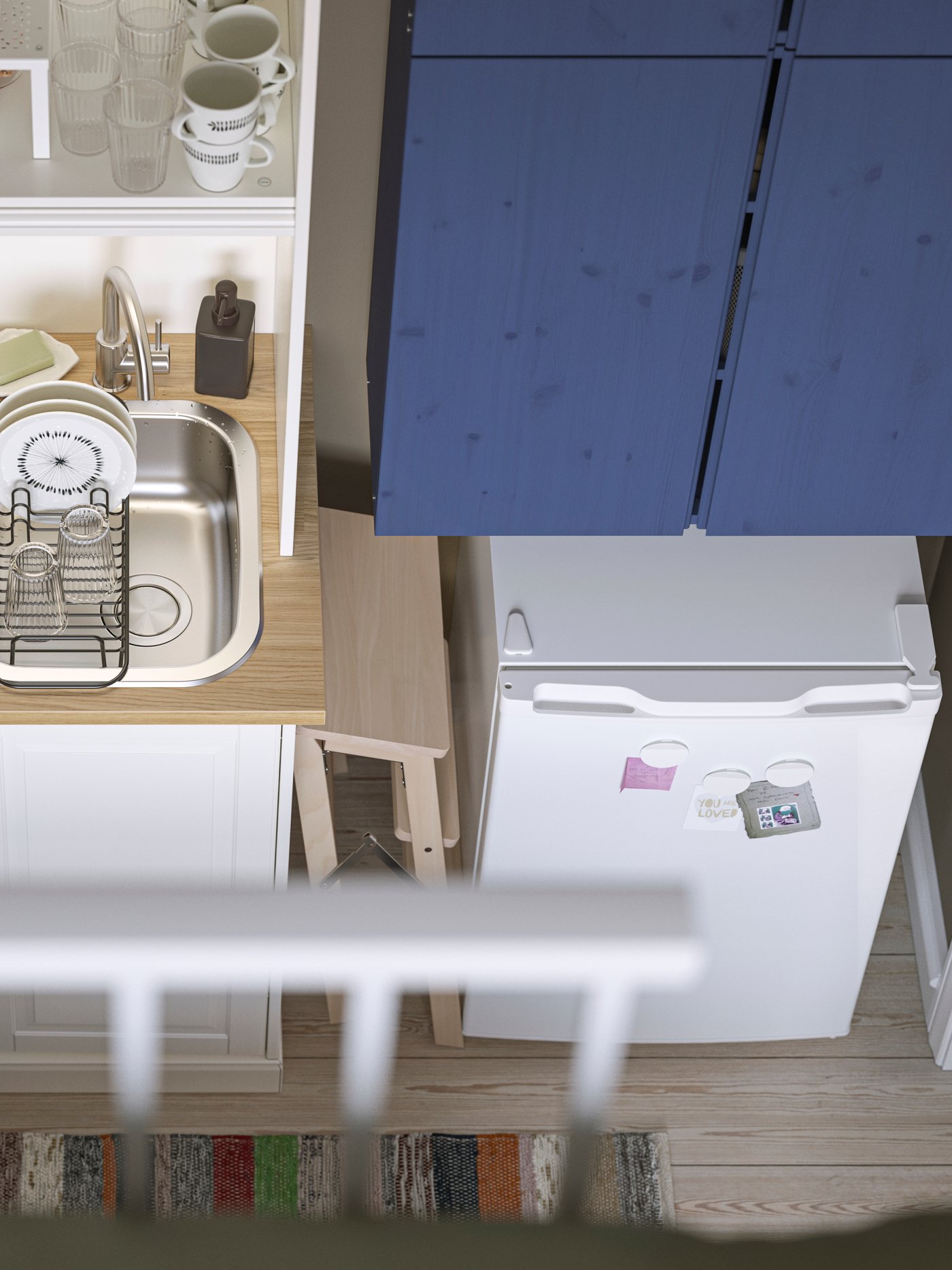 Ein Einzimmerapartment von oben mit Blick auf eine weiße ÖNNERUP Kochnische mit einem blauen IVAR Schrank und einem LAGAN Kühlschrank.