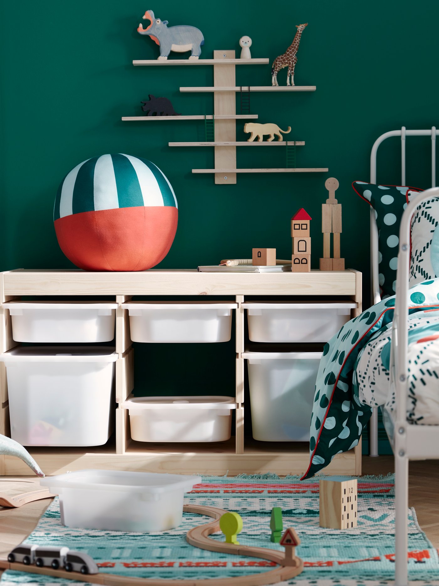 Una habitación infantil con un mueble TROFAST con cajones blancos. Encima del mueble una pelota.