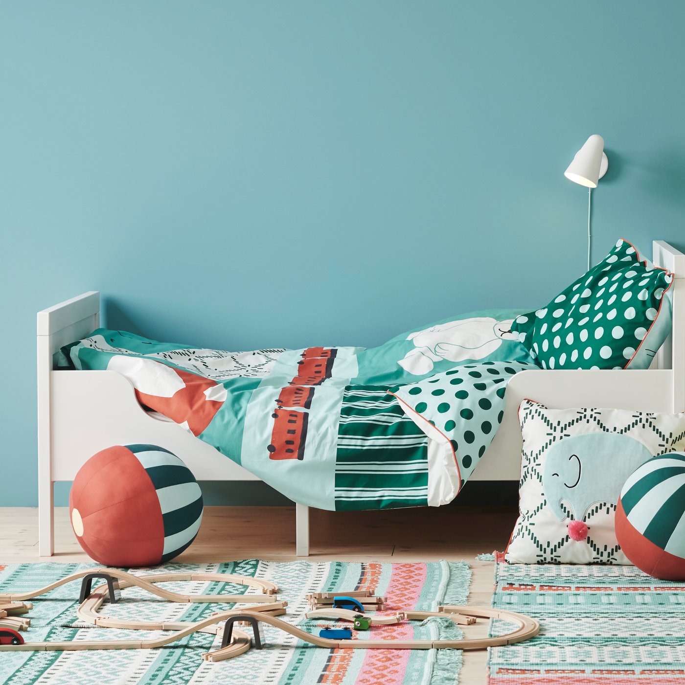 Two SUNDVIK beds with KÄPPHÄST quilt covers and pillowcases stand in a bedroom with a cushion and toys on the floor.
