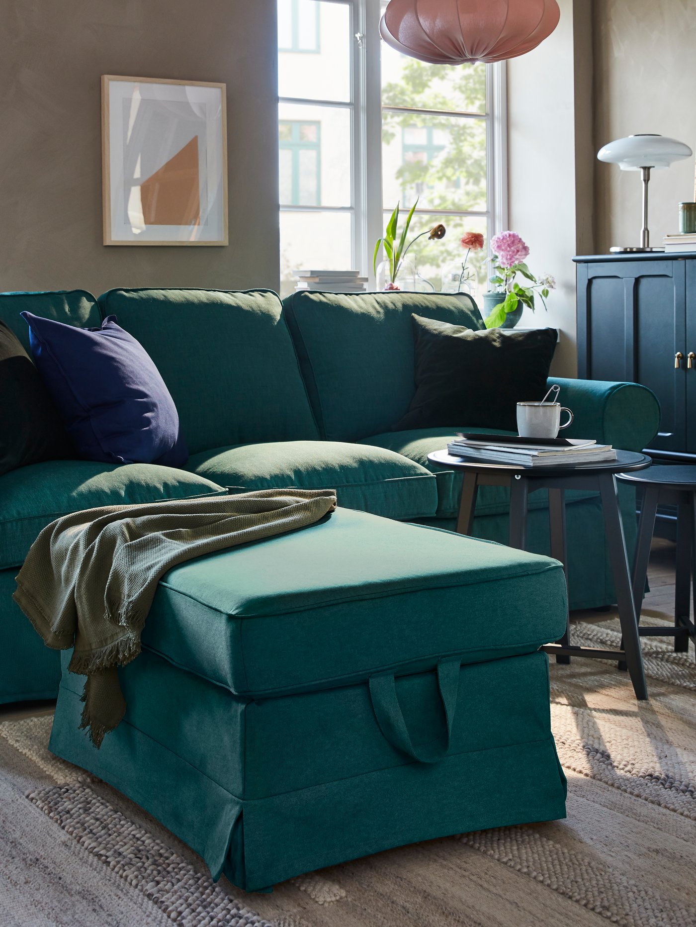 Chaise lounge de color verde turquesa de la serie EKTORP con una manta encima de la serie ODDRUN.