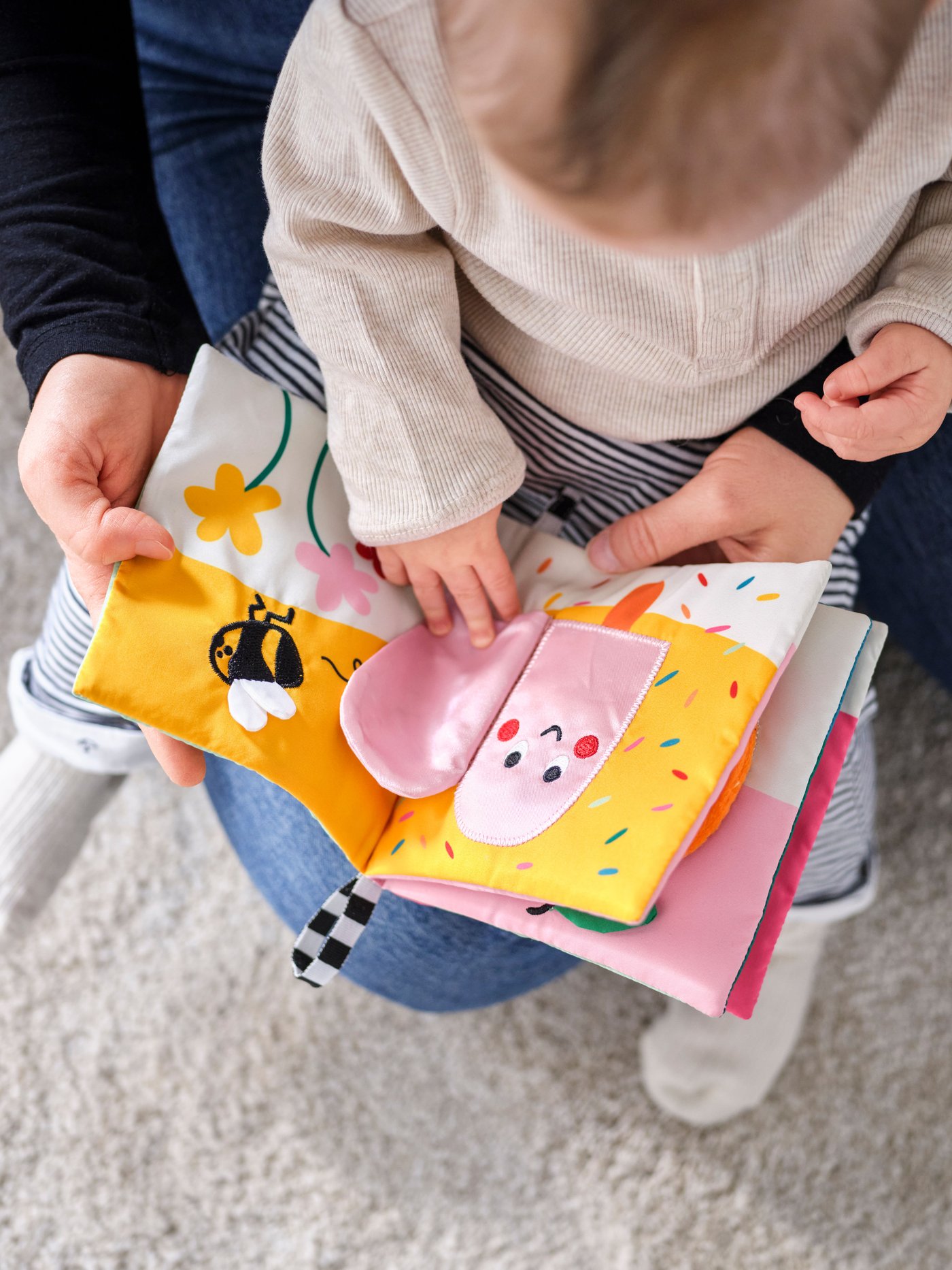 Libro infantil para bebés GRÖNFINK en las manos de un bebé y su mamá.