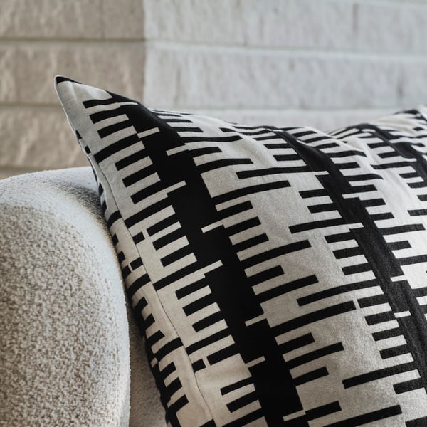 An off-white/black STOCKHOLM 2025 cushion cover