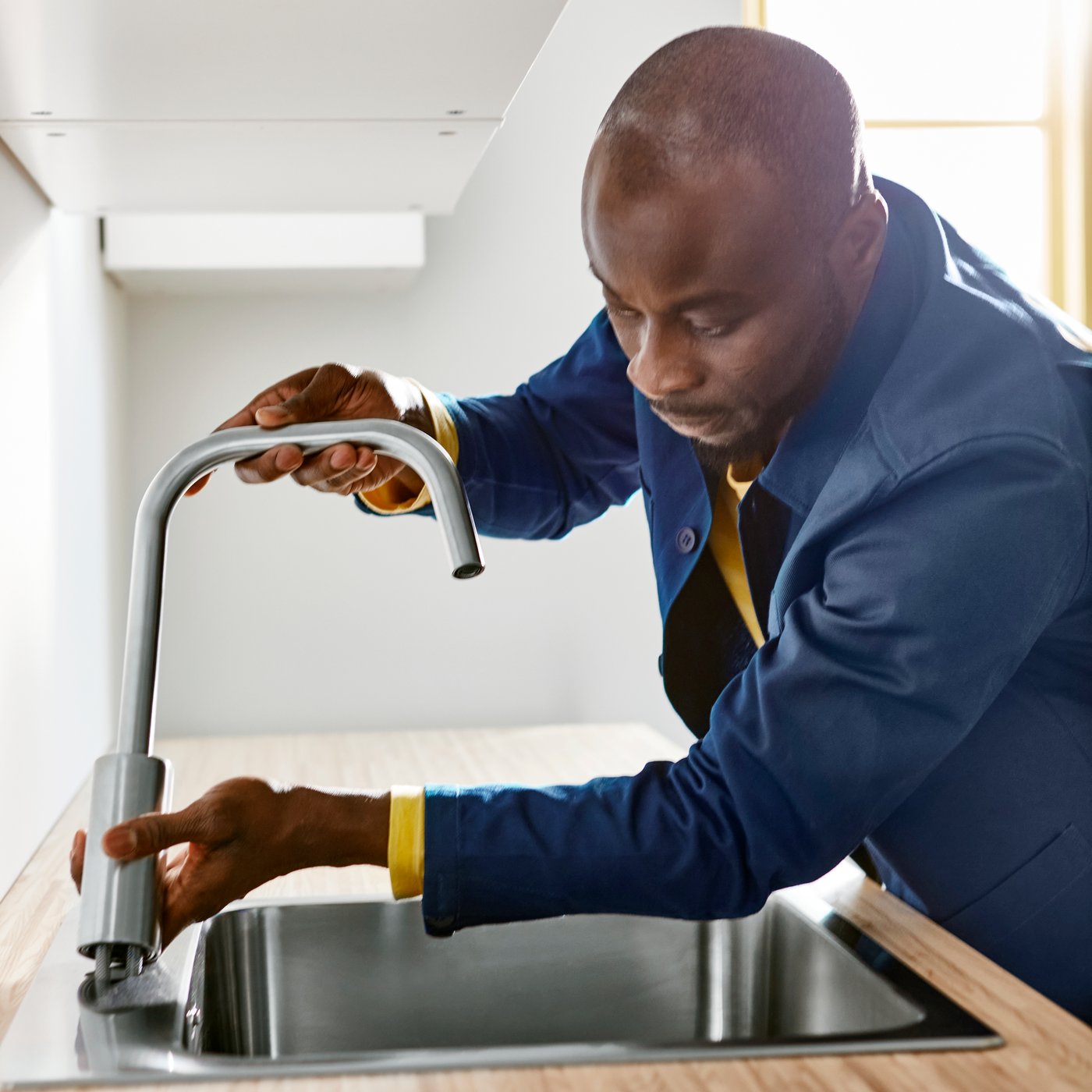 An IKEA collegue is installing a kitchen sink