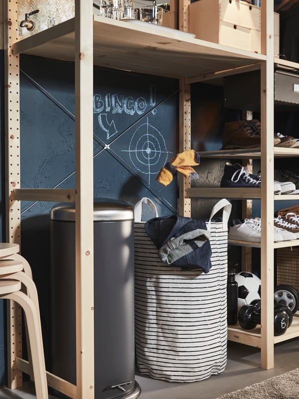 A large pedal bin and a KLUNKA laundry bag sit on the floor under a shelf in a big wooden IVAR storage combination.