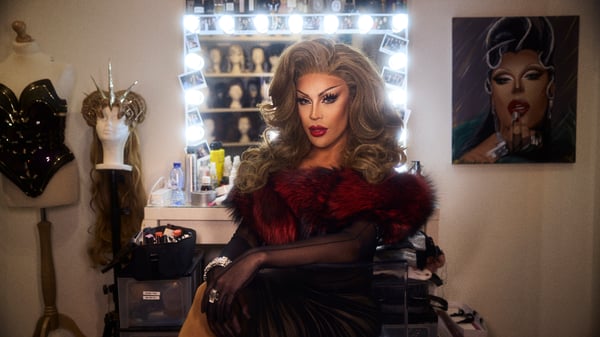 Envy Peru i fuld makeup klædt ud i drag, mens hun sidder foran sit spejl i påklædningsværelset.