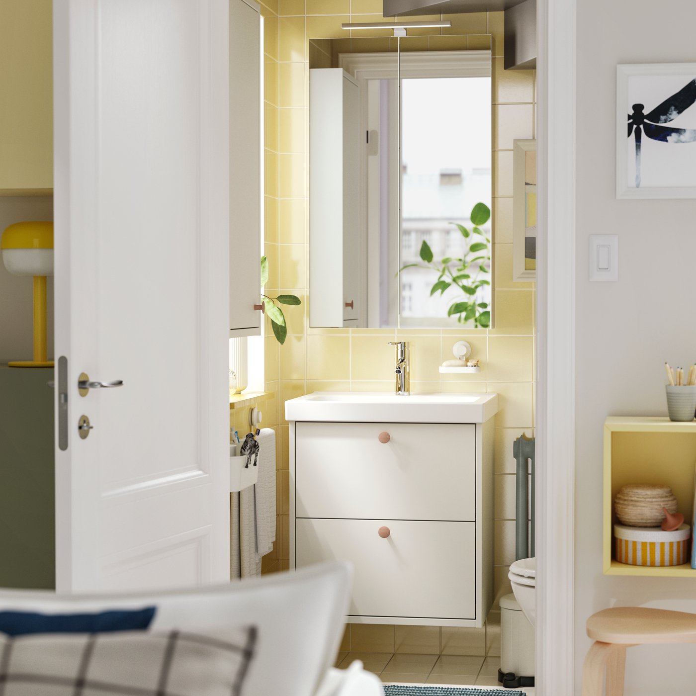 Die Tür zu einer kleinen Toilette steht offen und im Inneren befindet sich ein weisser HAVBÄCK Waschbeckenschrank mit zwei Schubladen und einem Spiegelschrank darüber.