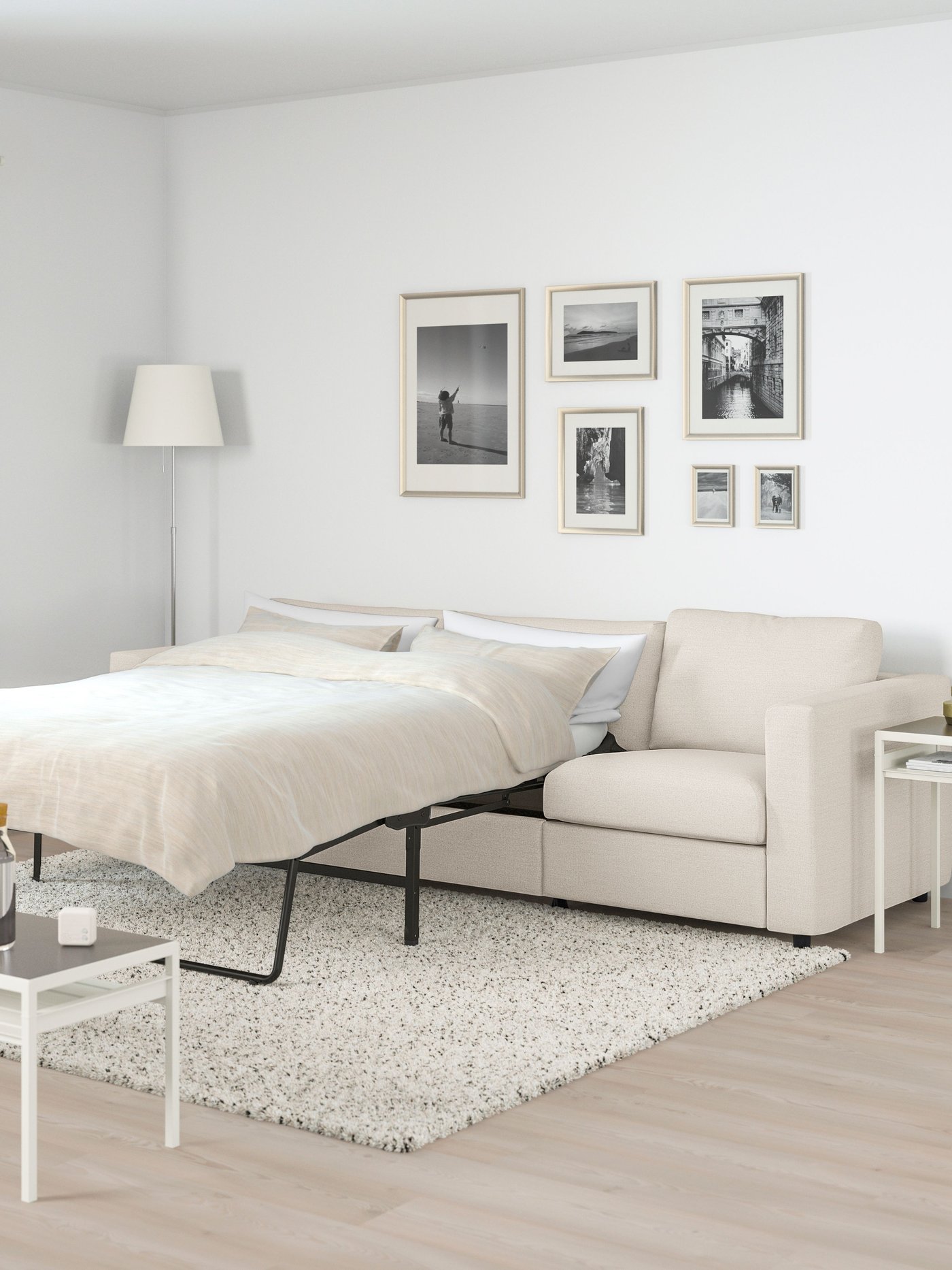 En vimle 3 seter sovesofa i beige farge i en stue med lys gulvteppe. 